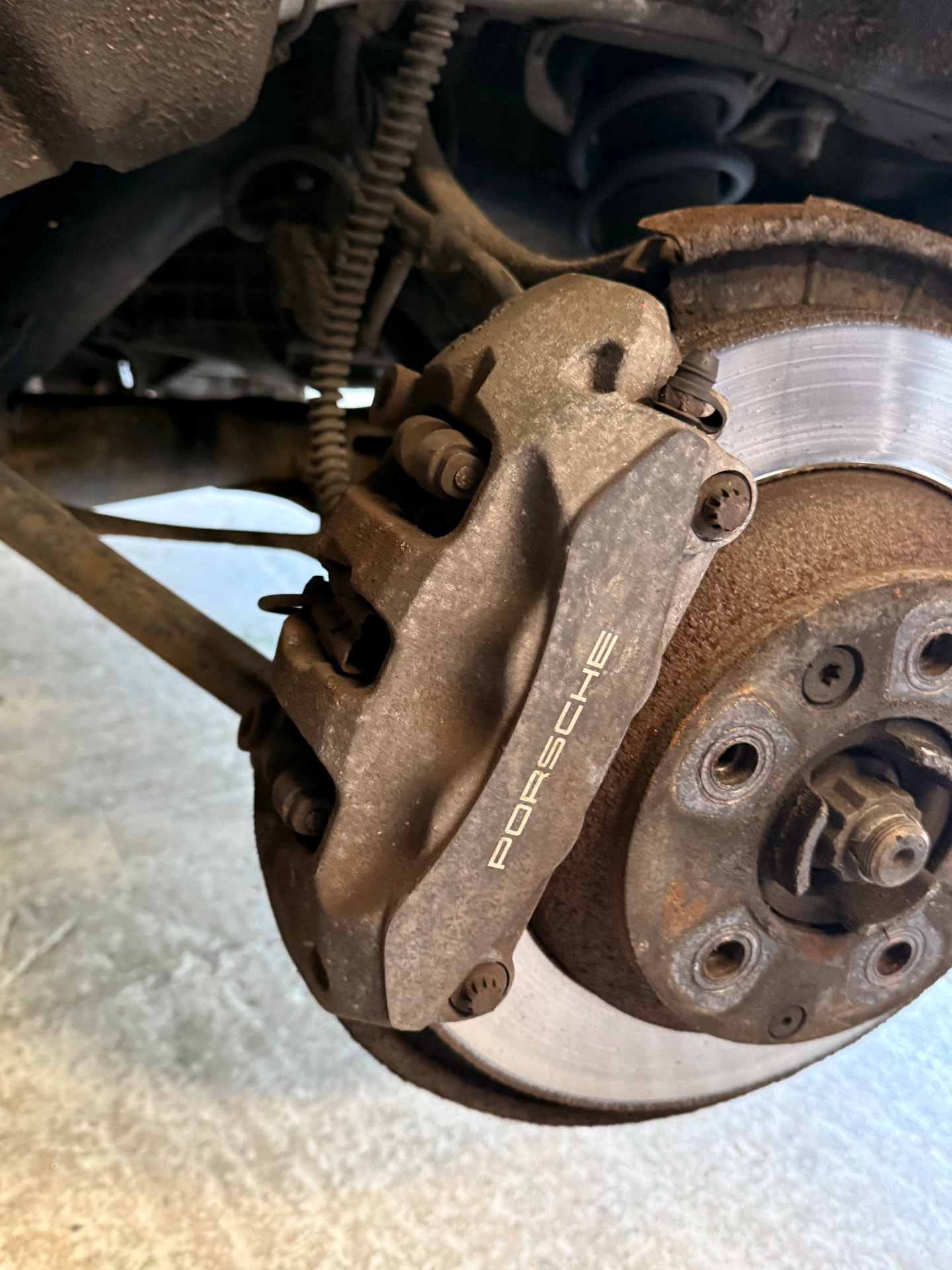 Porsche brake caliper before and after painting in blue by WheelMaster